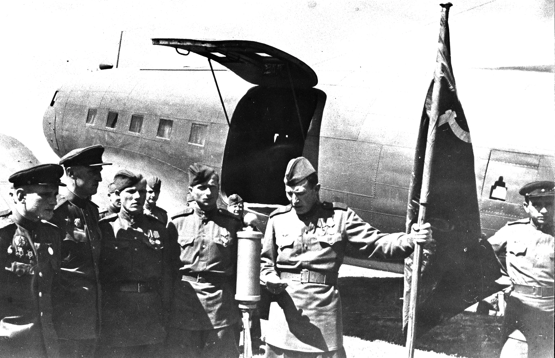 Фотография солдат с знаменем Победы на фоне самолета